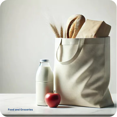 a simple, clean setup of groceries on a light-colored surface. There is a reusable fabric bag filled with a loaf of bread, a paper-wrapped package, and some wheat stalks sticking out of the top. Next to the bag, there is a glass bottle of milk and a red apple. In the bottom left corner, there is small text that reads "Food and Groceries." The overall aesthetic is minimalistic and fresh.